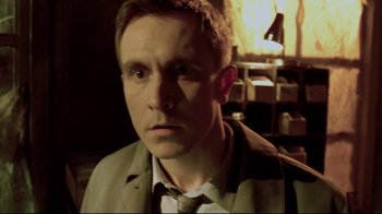 Movie still from “Saw 3D” (2010), directed by Kevin Greutert – A person wearing a suit and tie; Close Up shot, High angle