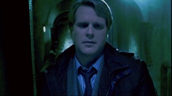 Movie still from “Saw 3D” (2010), directed by Kevin Greutert – A man in a jacket and tie in a dark room; Close Up shot, Over the shoulder angle