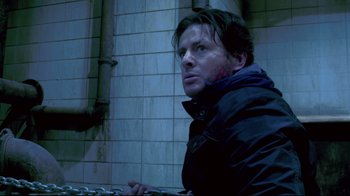 Movie still from “Saw 3D” (2010), directed by Kevin Greutert – A man in a black jacket is holding a computer keyboard; Close Up shot, Low angle