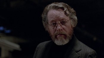 Movie still from “Scanners” (1981), directed by David Cronenberg – An older man with a beard and glasses; Close Up shot, Over the shoulder angle
