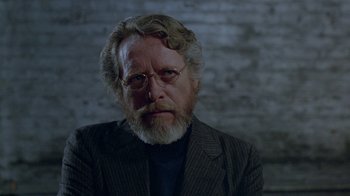 Movie still from “Scanners” (1981), directed by David Cronenberg – An older man with a beard and glasses; Close Up shot, Over the shoulder angle