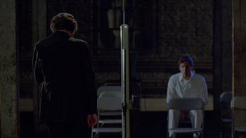 Movie still from “Scanners” (1981), directed by David Cronenberg – Two people sitting in chairs in front of one another; Wide shot, Over the shoulder angle