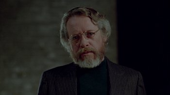 Movie still from “Scanners” (1981), directed by David Cronenberg – An older man with a beard wearing a suit; Close Up shot, Over the shoulder angle