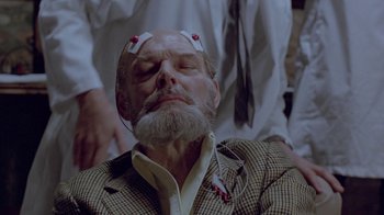 Movie still from “Scanners” (1981), directed by David Cronenberg – An old man with a beard and a mustache wearing a suit and tie; Close Up shot, High angle