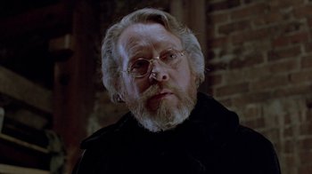 Movie still from “Scanners” (1981), directed by David Cronenberg – An older man with a beard and glasses; Close Up shot, Over the shoulder angle