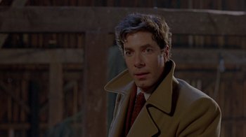 Movie still from “Scanners” (1981), directed by David Cronenberg – A man wearing a coat and tie in a dark room; Close Up shot, Over the shoulder angle