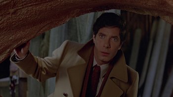 Movie still from “Scanners” (1981), directed by David Cronenberg – A man in a trench coat holding an umbrella; Close Up shot, Over the shoulder angle