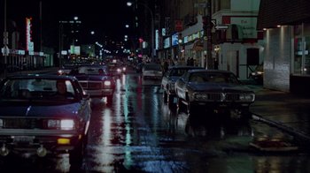 Movie still from “Scanners” (1981), directed by David Cronenberg – A city street filled with lots of traffic at night; Extreme Wide shot, High angle