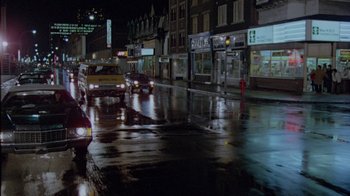Movie still from “Scanners” (1981), directed by David Cronenberg – Cars are parked on the side of the road in the rain; Extreme Wide shot, High angle
