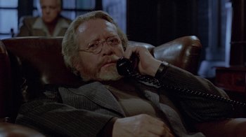 Movie still from “Scanners” (1981), directed by David Cronenberg – An older man talking on a phone while sitting in a chair; Close Up shot, Over the shoulder angle