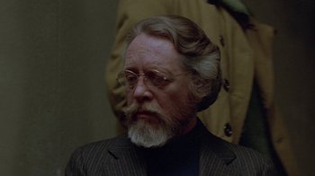 Movie still from “Scanners” (1981), directed by David Cronenberg – An older man with a beard and glasses; Close Up shot, Over the shoulder angle