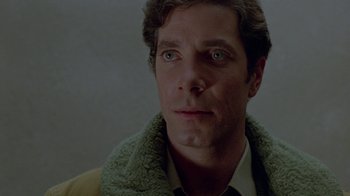 Movie still from “Scanners” (1981), directed by David Cronenberg – A person wearing a jacket; Close Up shot, Over the shoulder angle