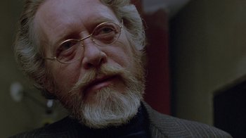Movie still from “Scanners” (1981), directed by David Cronenberg – An older man with a beard and glasses; Close Up shot, Over the shoulder angle
