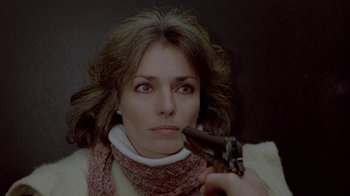 Movie still from “Scanners” (1981), directed by David Cronenberg – A woman holding a gun up to her mouth; Close Up shot, Overhead angle