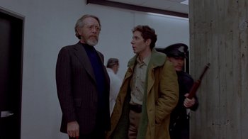 Movie still from “Scanners” (1981), directed by David Cronenberg – Two men standing next to each other in a room; Medium shot, Over the shoulder angle