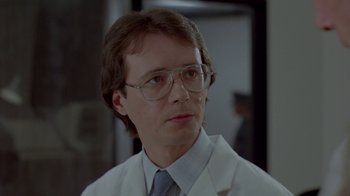 Movie still from “Scanners” (1981), directed by David Cronenberg – A man in a white lab coat wearing glasses; Close Up shot, Low angle