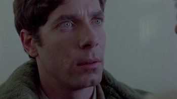 Movie still from “Scanners” (1981), directed by David Cronenberg – A man's face with green eyes; Close Up shot, Low angle