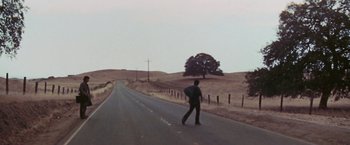 Movie still from “Scarecrow” (1973), directed by Jerry Schatzberg – A man walking down the middle of a road; Extreme Wide shot, High angle