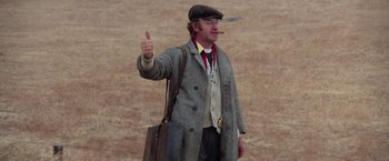 Movie still from “Scarecrow” (1973), directed by Jerry Schatzberg – A man in a hat and a suit giving a thumbs - up; Medium shot, Low angle