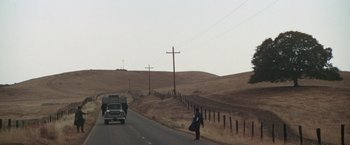 Movie still from “Scarecrow” (1973), directed by Jerry Schatzberg – A person walking down a road with a truck in the background; Extreme Wide shot, Low angle