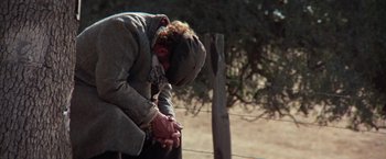 Movie still from “Scarecrow” (1973), directed by Jerry Schatzberg – An old man sitting on the side of a fence looking down; Medium shot, High angle