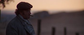 Movie still from “Scarecrow” (1973), directed by Jerry Schatzberg – A man wearing a hat and glasses smoking a cigarette; Close Up shot, Low angle