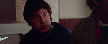 Movie still from “Scarecrow” (1973), directed by Jerry Schatzberg – A person sitting in front of a wall; Close Up shot, Over the shoulder angle