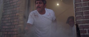 Movie still from “Scarecrow” (1973), directed by Jerry Schatzberg – A man in a white t - shirt with blood all over his face; Medium shot, Low angle