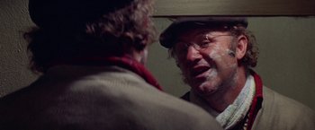 Movie still from “Scarecrow” (1973), directed by Jerry Schatzberg – A man in a hat and glasses talking to another man in a hat; Close Up shot, Over the shoulder angle