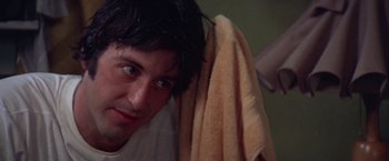 Movie still from “Scarecrow” (1973), directed by Jerry Schatzberg – A person holding a towel over their head; Close Up shot, Over the shoulder angle
