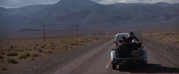 Movie still from “Scarecrow” (1973), directed by Jerry Schatzberg – A man riding in the back of a truck down a road; Extreme Wide shot, High angle