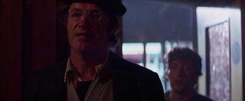 Movie still from “Scarecrow” (1973), directed by Jerry Schatzberg – A man in a hat smoking a cigarette in front of a woman; Close Up shot, Over the shoulder angle