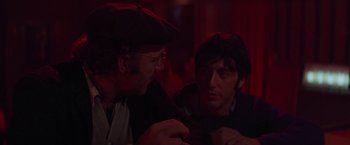 Movie still from “Scarecrow” (1973), directed by Jerry Schatzberg – Two men sitting in front of each other in a dark room; Close Up shot, Over the shoulder angle