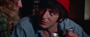 Movie still from “Scarecrow” (1973), directed by Jerry Schatzberg – A person holding a drink; Close Up shot, Over the shoulder angle