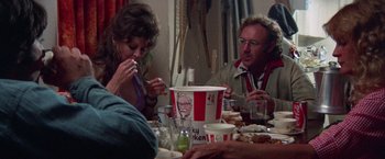 Movie still from “Scarecrow” (1973), directed by Jerry Schatzberg – A group of people sitting around a table eating kfc; Medium shot, Over the shoulder angle