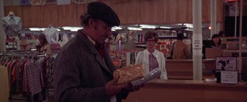 Movie still from “Scarecrow” (1973), directed by Jerry Schatzberg – An older man holding a piece of bread in front of an older woman; Medium shot, Over the shoulder angle
