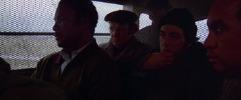 Movie still from “Scarecrow” (1973), directed by Jerry Schatzberg – A man with a hat and glasses is sitting in a car; Close Up shot, Over the shoulder angle