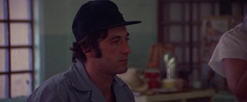 Movie still from “Scarecrow” (1973), directed by Jerry Schatzberg – A person wearing a hat; Close Up shot, Over the shoulder angle