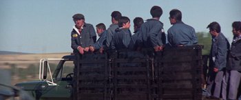 Movie still from “Scarecrow” (1973), directed by Jerry Schatzberg – A group of men sitting on top of a wooden box; Medium shot, Low angle