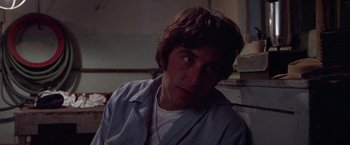 Movie still from “Scarecrow” (1973), directed by Jerry Schatzberg – A man with long brown hair wearing a white shirt; Close Up shot, Low angle