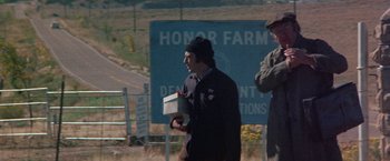 Movie still from “Scarecrow” (1973), directed by Jerry Schatzberg – A man holding a box in his hands; Medium shot, Low angle