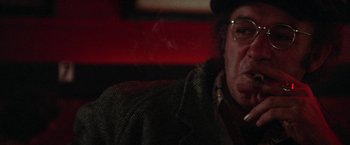 Movie still from “Scarecrow” (1973), directed by Jerry Schatzberg – A man sitting down with a cigarette in his mouth; Close Up shot, Low angle