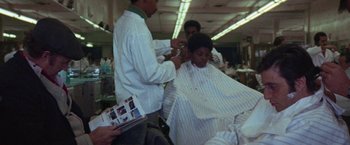 Movie still from “Scarecrow” (1973), directed by Jerry Schatzberg – A man getting his hair cut in a barber shop; Medium shot, Over the shoulder angle