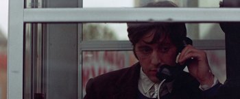 Movie still from “Scarecrow” (1973), directed by Jerry Schatzberg – A man sitting in front of a window on a phone; Close Up shot, Low angle