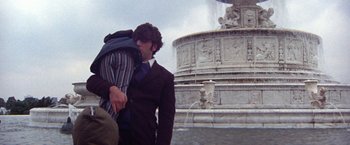Movie still from “Scarecrow” (1973), directed by Jerry Schatzberg – Two men in suits kissing in front of a fountain; Medium shot, Low angle