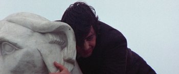 Movie still from “Scarecrow” (1973), directed by Jerry Schatzberg – A man with long black hair is holding a statue; Close Up shot, Low angle