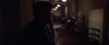 Movie still from “Scarecrow” (1973), directed by Jerry Schatzberg – A man wearing a hat is standing in a hallway; Wide shot, Over the shoulder angle