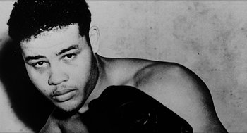 Movie still from “School Daze” (1988), directed by Spike Lee – Black and white photograph of a shirtless man with no shirt; Close Up shot, Low angle