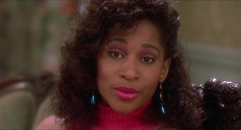 Movie still from “School Daze” (1988), directed by Spike Lee – A person wearing a pink sweater; Close Up shot, Low angle