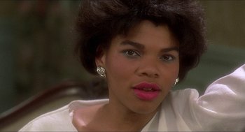 Movie still from “School Daze” (1988), directed by Spike Lee – A person wearing a white shirt and pink lipstick; Close Up shot, Low angle